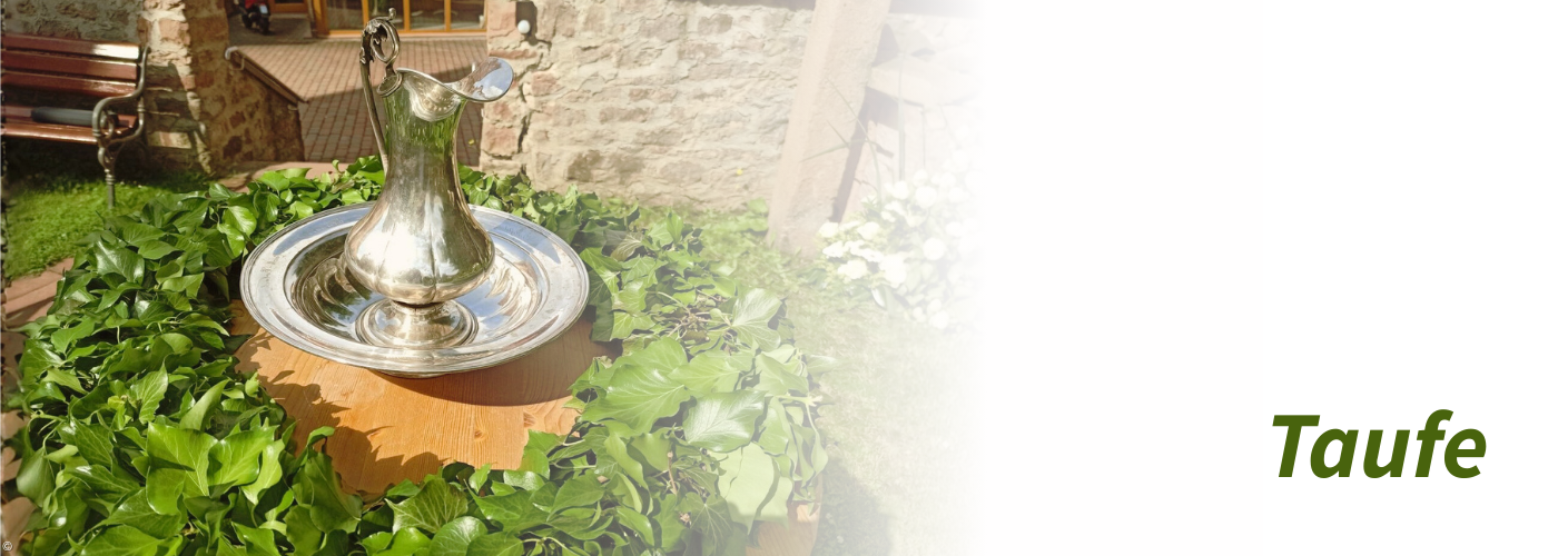 Eine silberne Taufschale und Taufkanne im Grünen